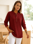 Woman wearing a red long-sleeve buttoned tunic top.