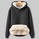 Black hoodie with cream sherpa fleece lining, featuring a drawstring hood and a large cozy front pocket.