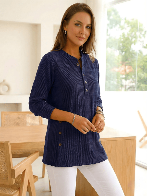 Woman wearing a navy long-sleeve tunic top with side buttons.