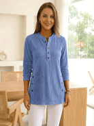Woman wearing a light blue long-sleeve buttoned tunic top.