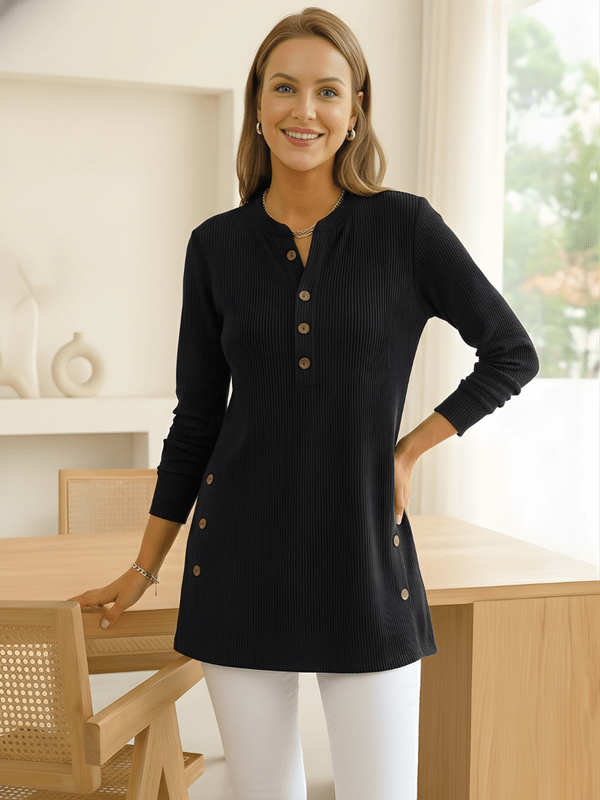 Woman wearing a black long-sleeve tunic top with side buttons.
