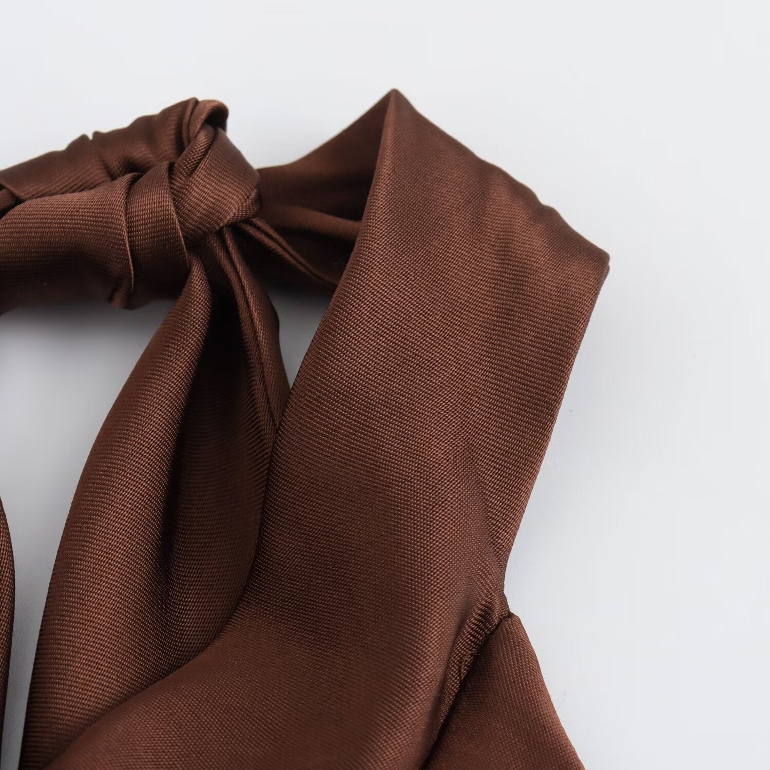 Side detail of the brown halter neck tie of dress.